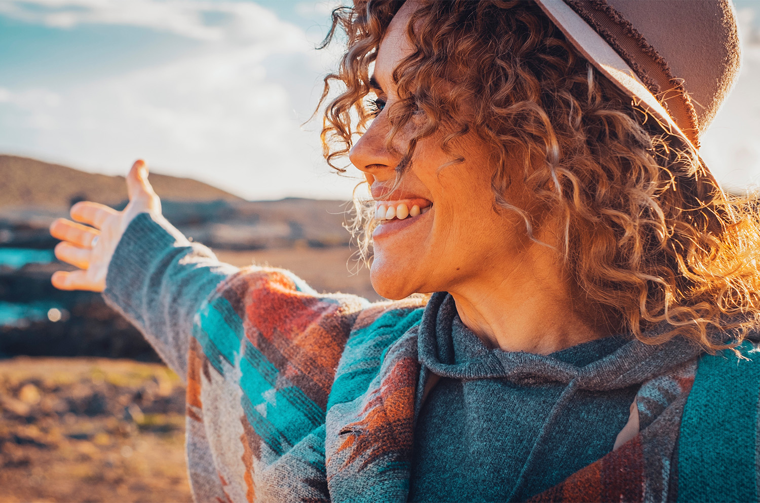 Happy traveler tourist enjoy landscape and nature beauty opening arms and smiling happy. Happiness and joyful female people lifestyle outstretching and admiring beautiful nature outdoors in leisure